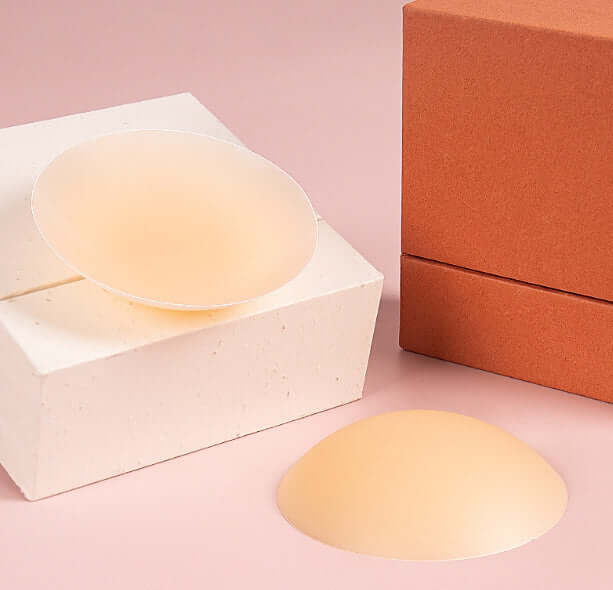 SOFT INTENTION silicone nipple covers on a pink background, showcasing their seamless and non-adhesive design.